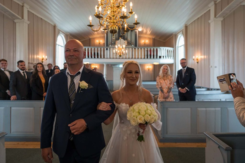 Bruden og hennes far går ned midtgangen i Hovin kirke.