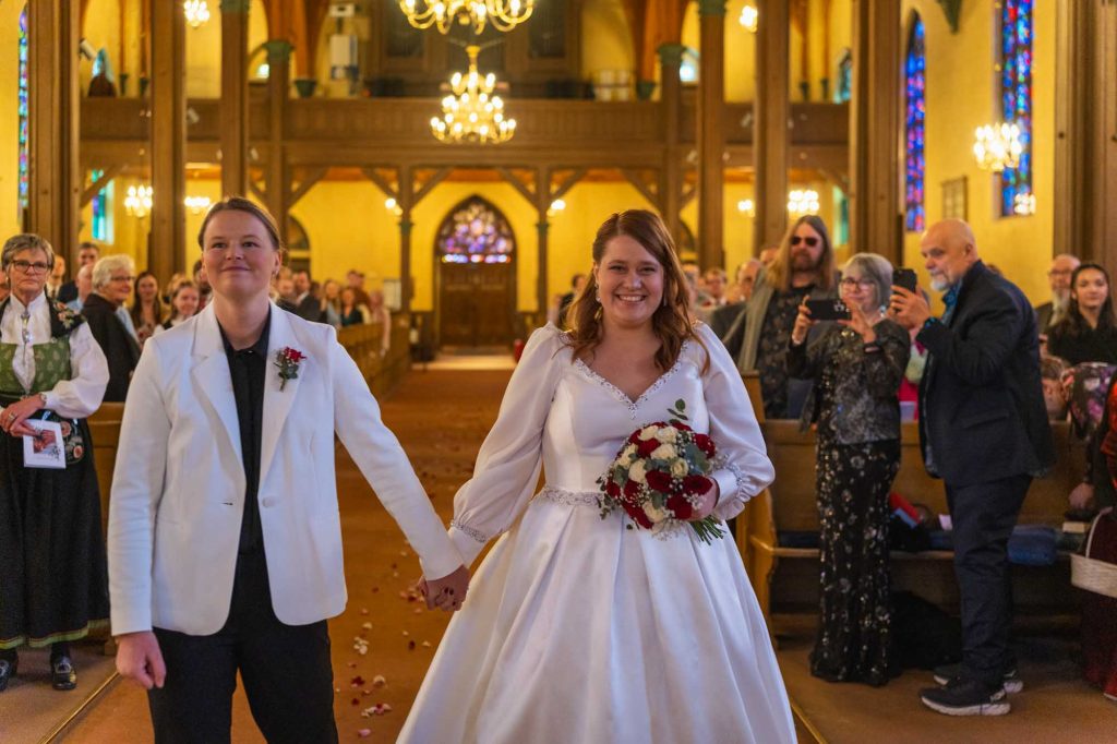 Lykkelig brudepar på vei mot alteret i Kampen kirke for å inngå ekteskap.