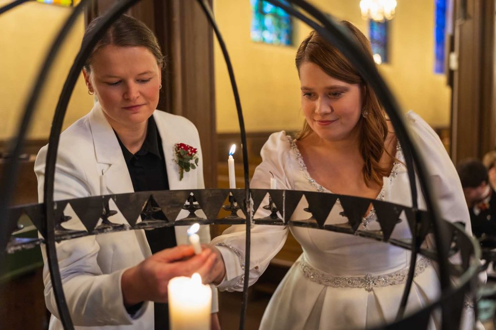 Bruden og brudgommen tenner et lys i kirken for å hedre de døde.