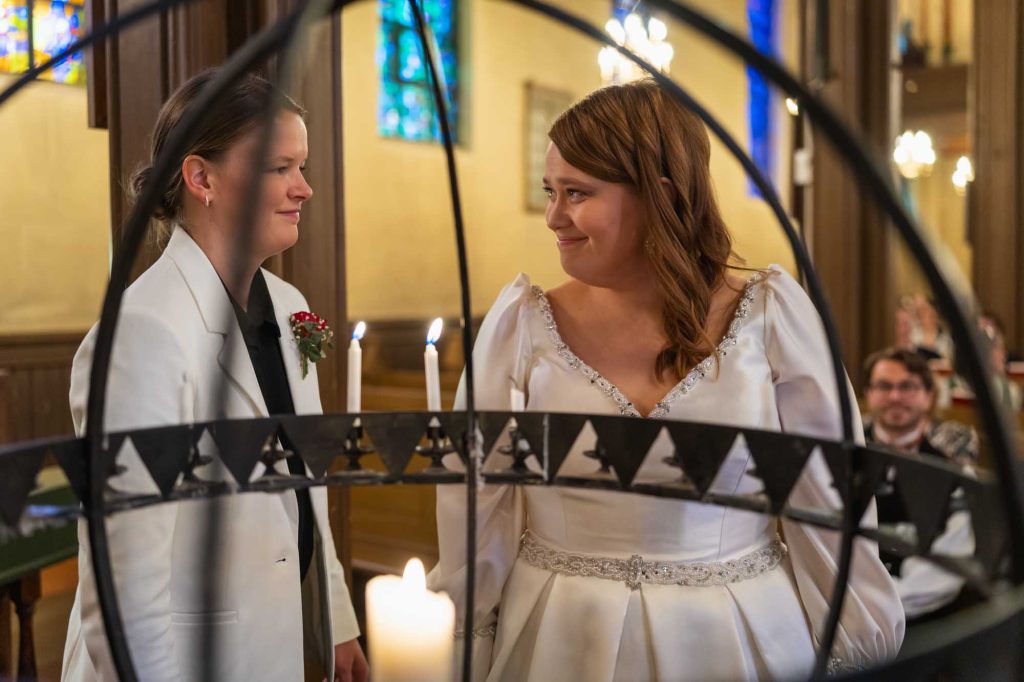 Bruden og brudgommen ser på hverandre og smiler etter å ha tent et lys i Kampen kirke.