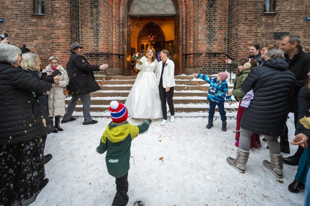 Gjestene kaster ris på det lykkelige paret utenfor Kampen kirke.