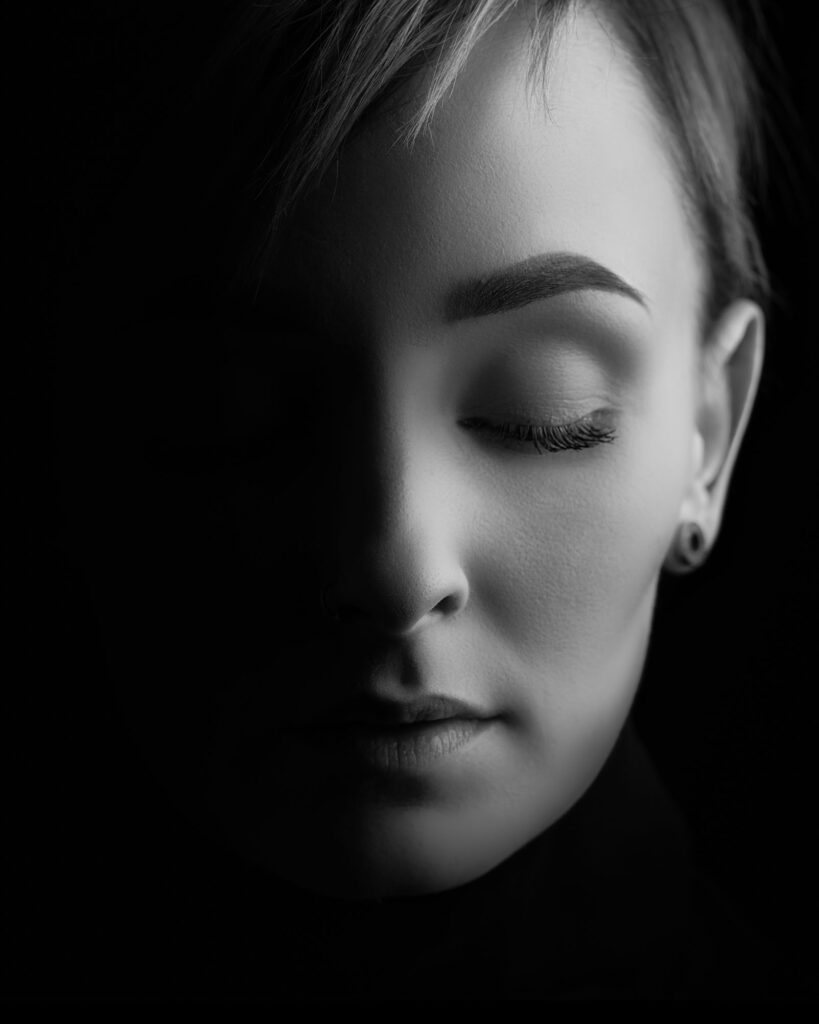 Et vakkert og drømmende fine-art portrett av en kvinne med lukkede øyne, fotografert i sort-hvitt.