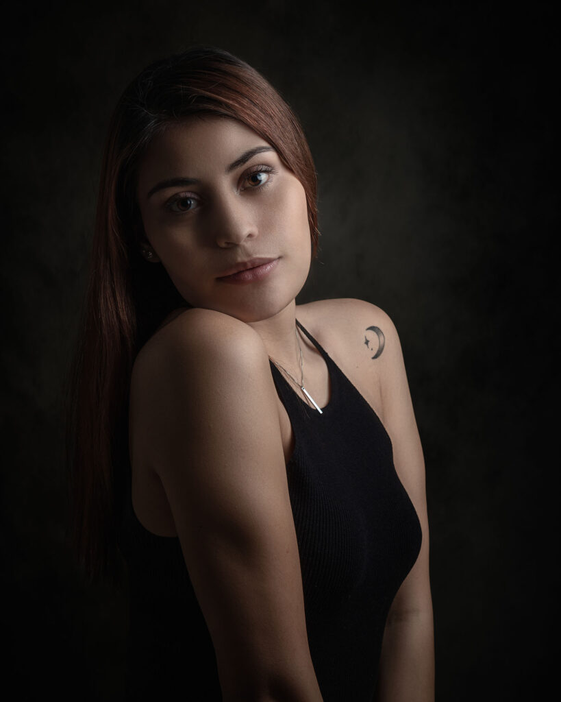 Nærbilde av en kvinne med en liten månetatovering på skulderen, profesjonelt fotografert av en studiofotograf i Oslo.