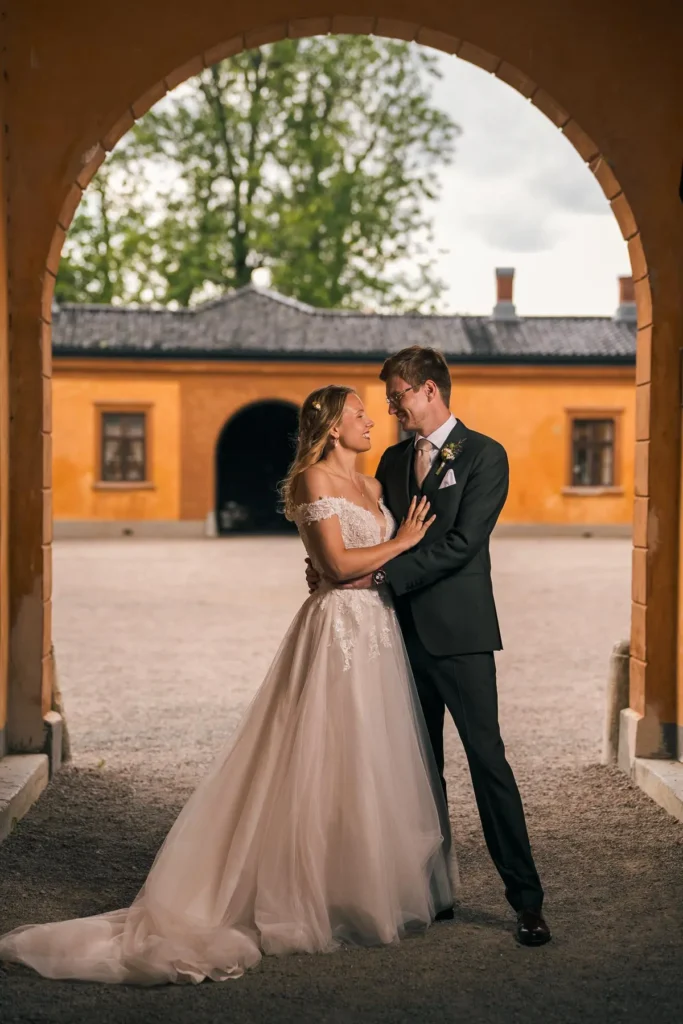 Eksklusivt brudepar portrettert i en historisk portgang på Bogstad gård i Oslo. Foto av PixPep.